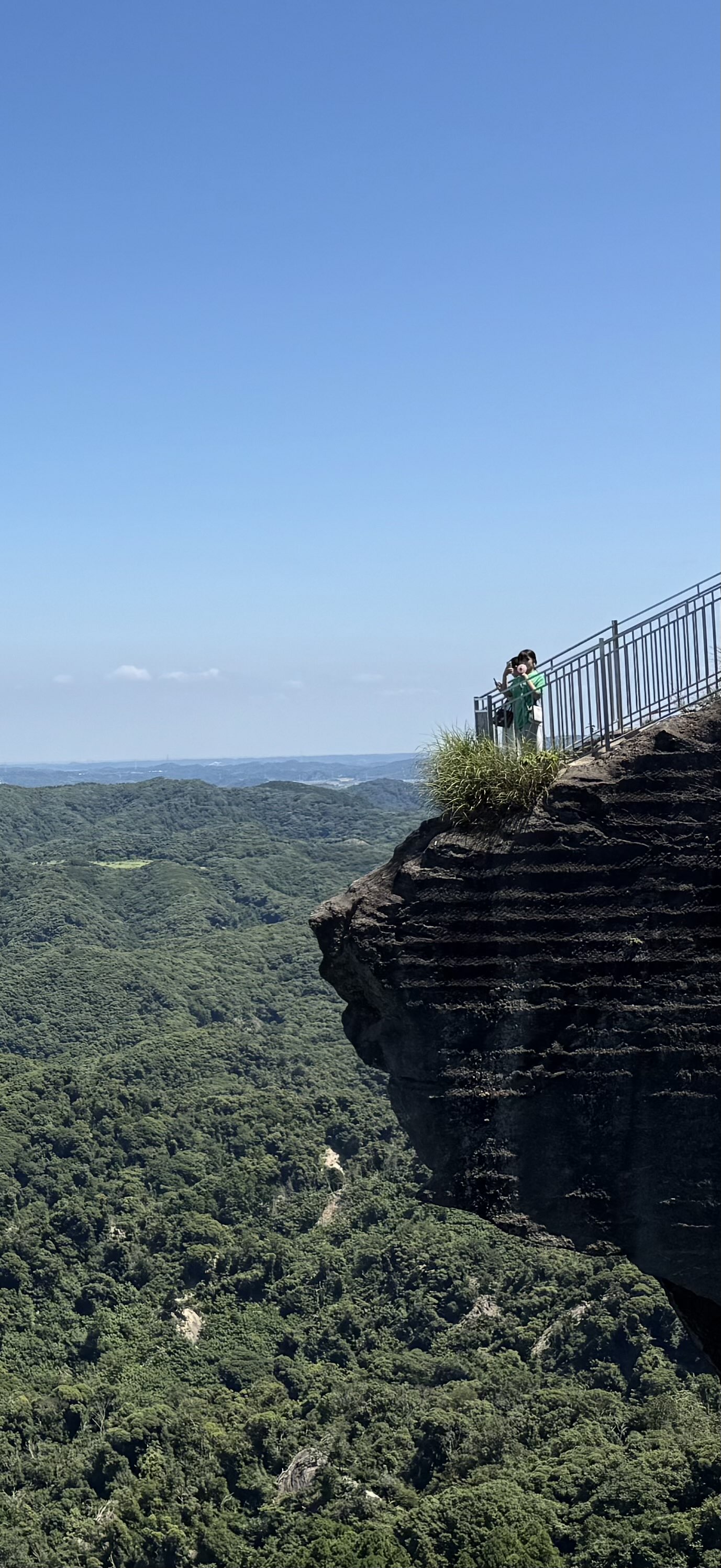 Overhanging Rock in Kyonan, Chiba Prefecture at the top of a mountain overlooking a vast mountain range / forrest